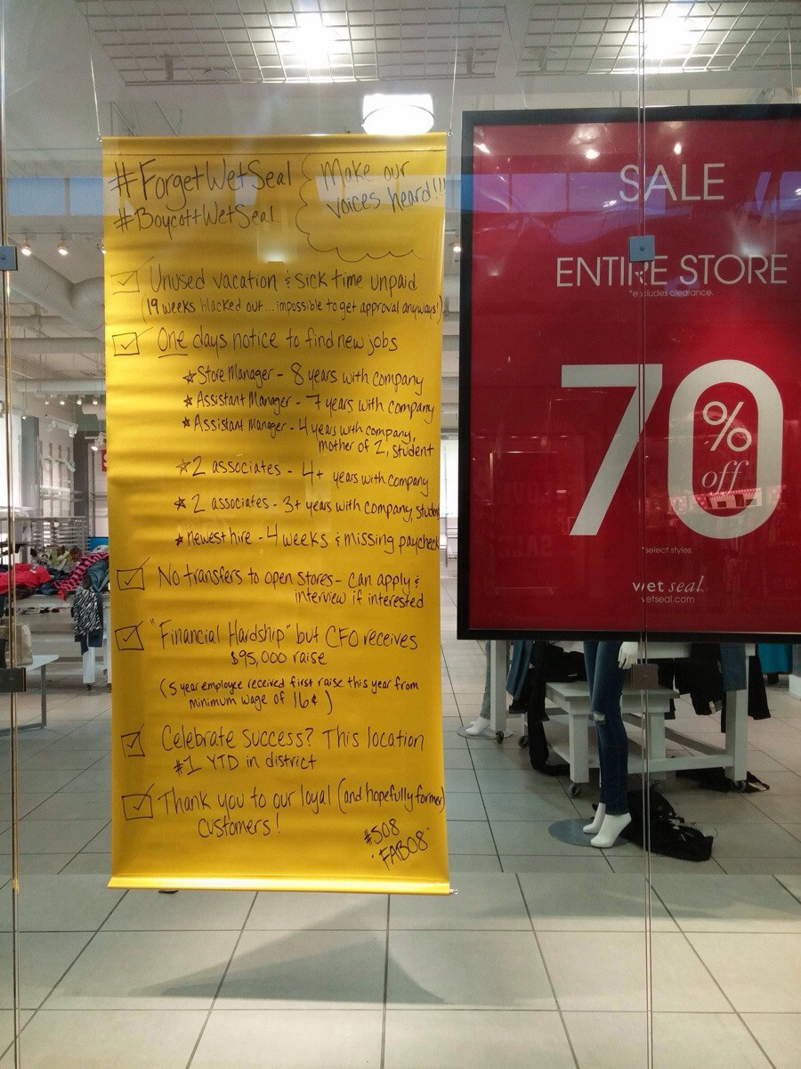 Employees leave a protest sign at failing Wet Seal mall store in Seattle